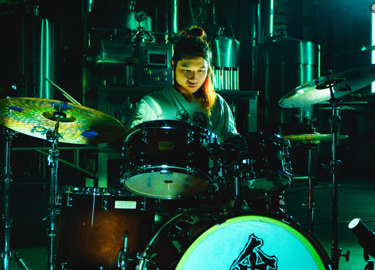 Drummer playing with green lighting